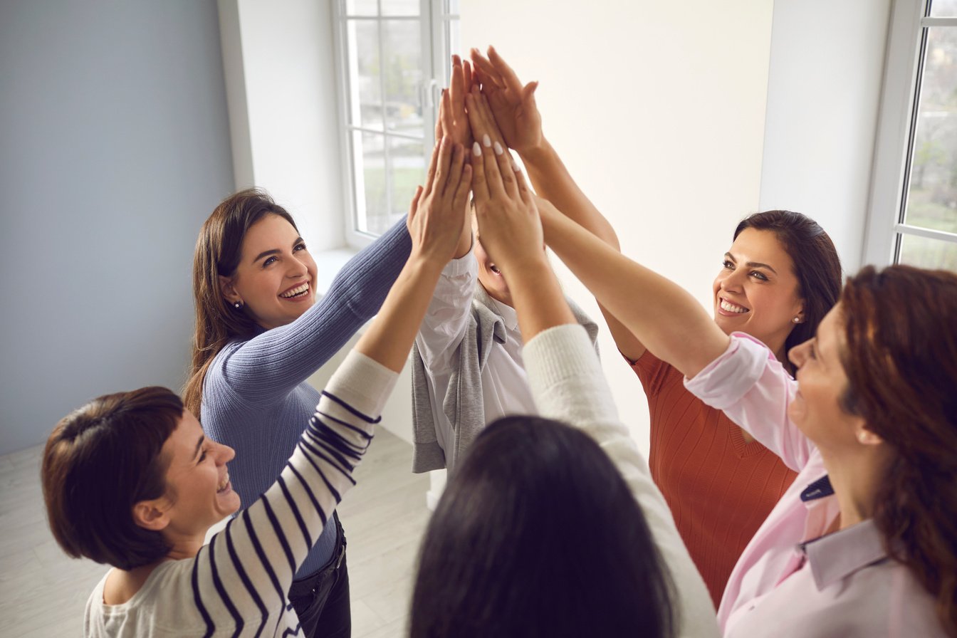 Team of Happy Young Women Joining Hands, Feeling United, Confident and Empowered